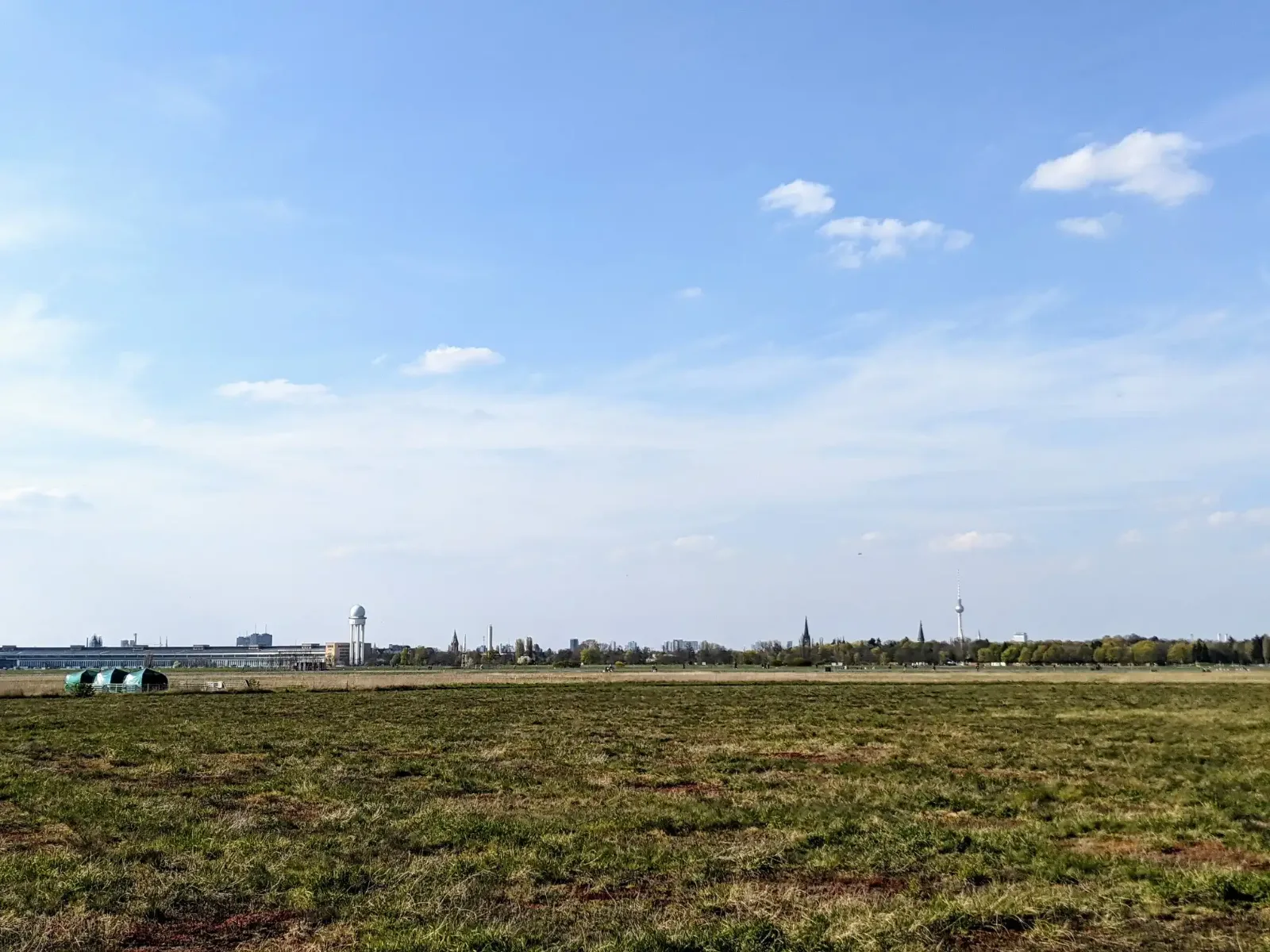 Weite des Tempelhofer Felds, am Horizont das Flughafengebäude mit Radarturm