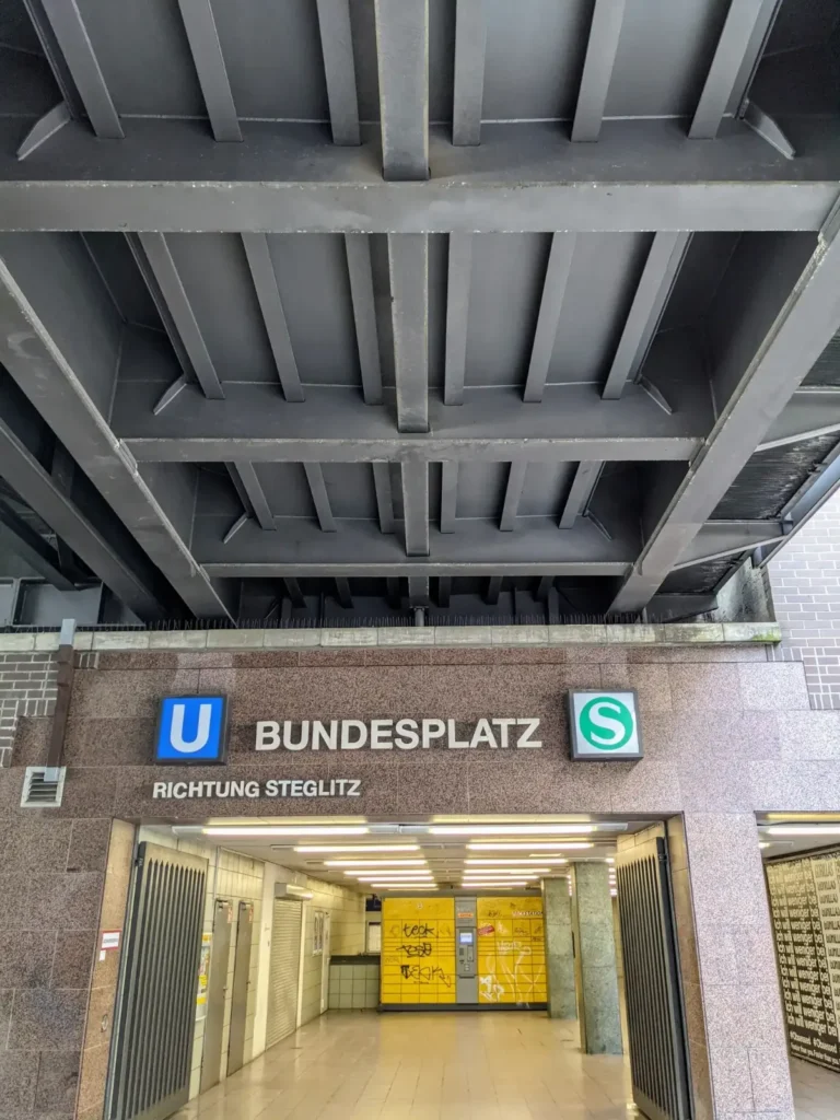 Eingang zum S- und U-Bahnhof Bundesplatz unter der Stahlbrücke der Ringbahn
