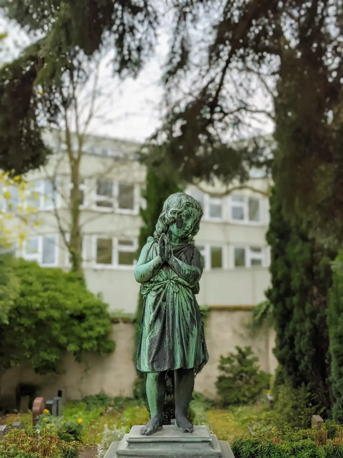Grün patinierte Bronzefigur eines betenden Mädchens auf dem Luisenfriedhof II in Berlin-Westend