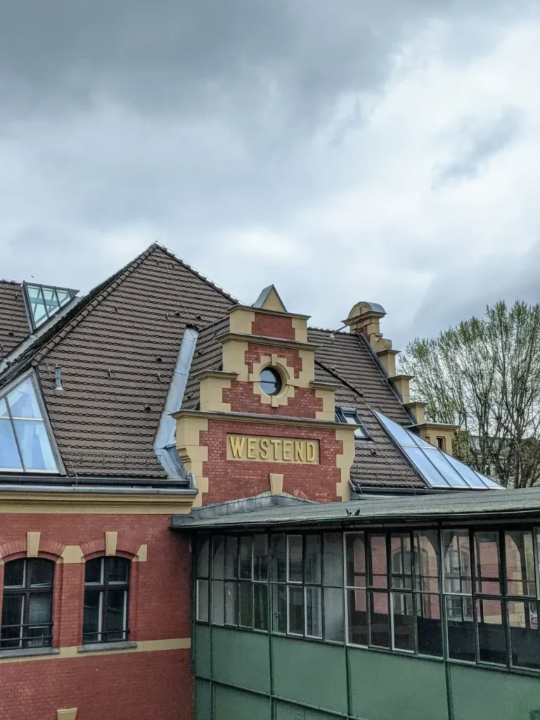 Roter Backsteingiebel mit Schriftzug Westend über den gläsernen Bahnsteigbauten am S-Bahnhof Westend in Berlin