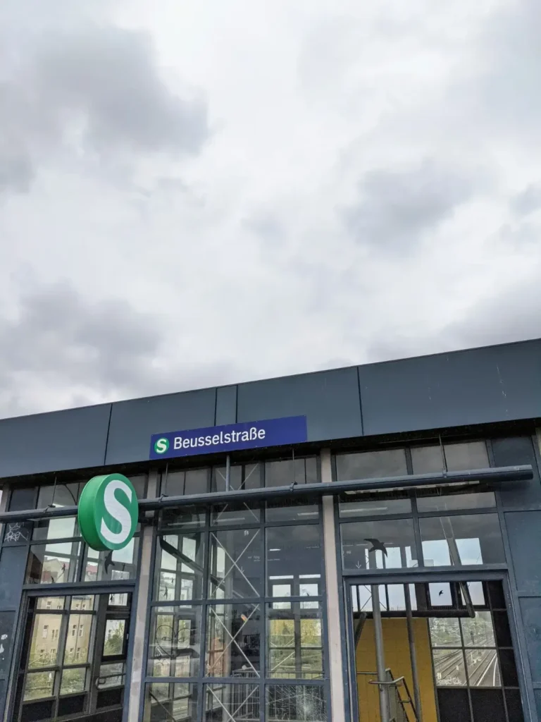 Gläserner Zugang zum S-Bahnhof Beusselstraße in Berlin-Moabit mit Bahnhofsschild