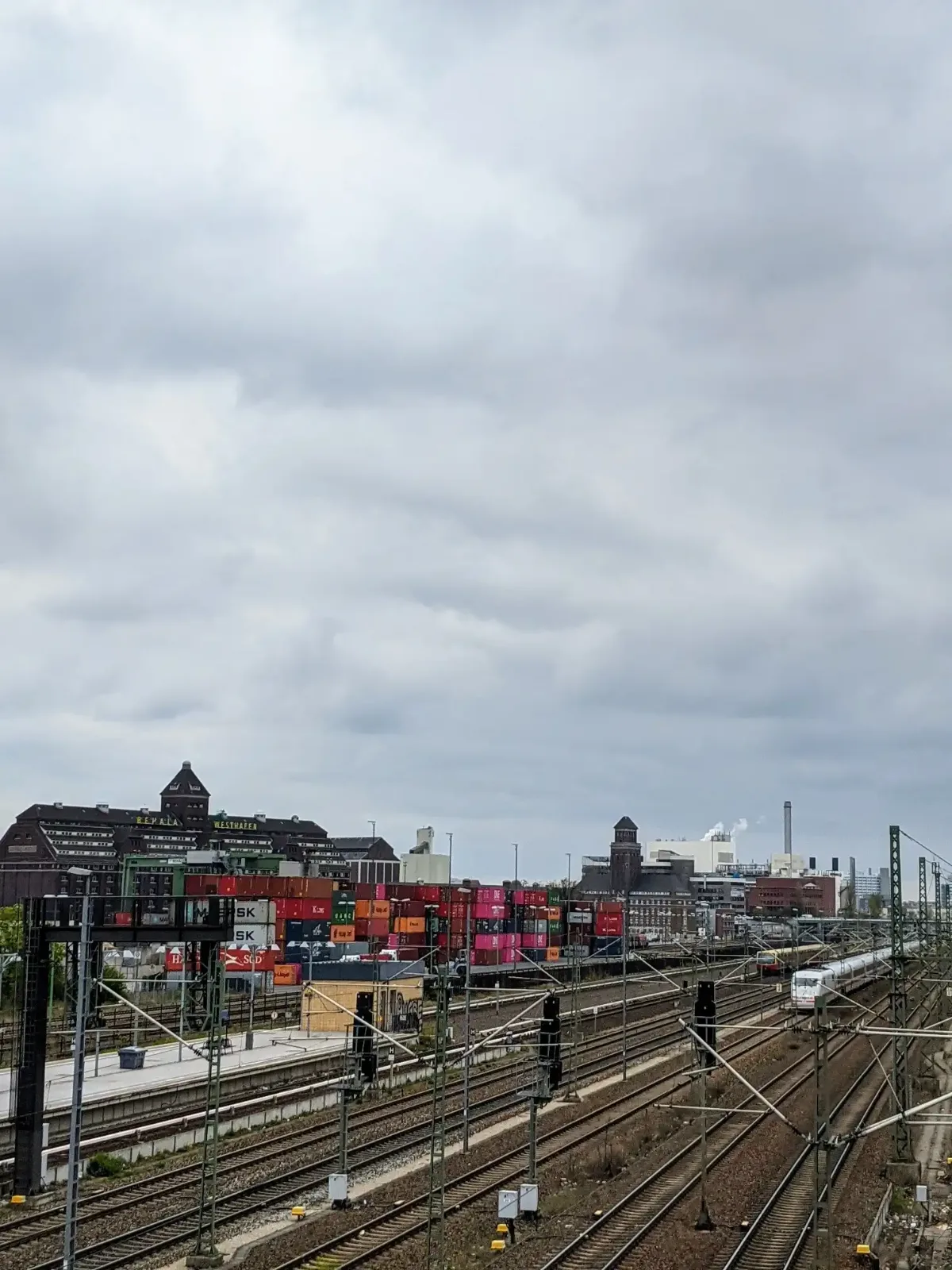 Blick von der Beusselbrücke in Berlin-Moabit über Gleise, Containerstapel und einen ICE zu den Türmen und Speichern des Westhafens