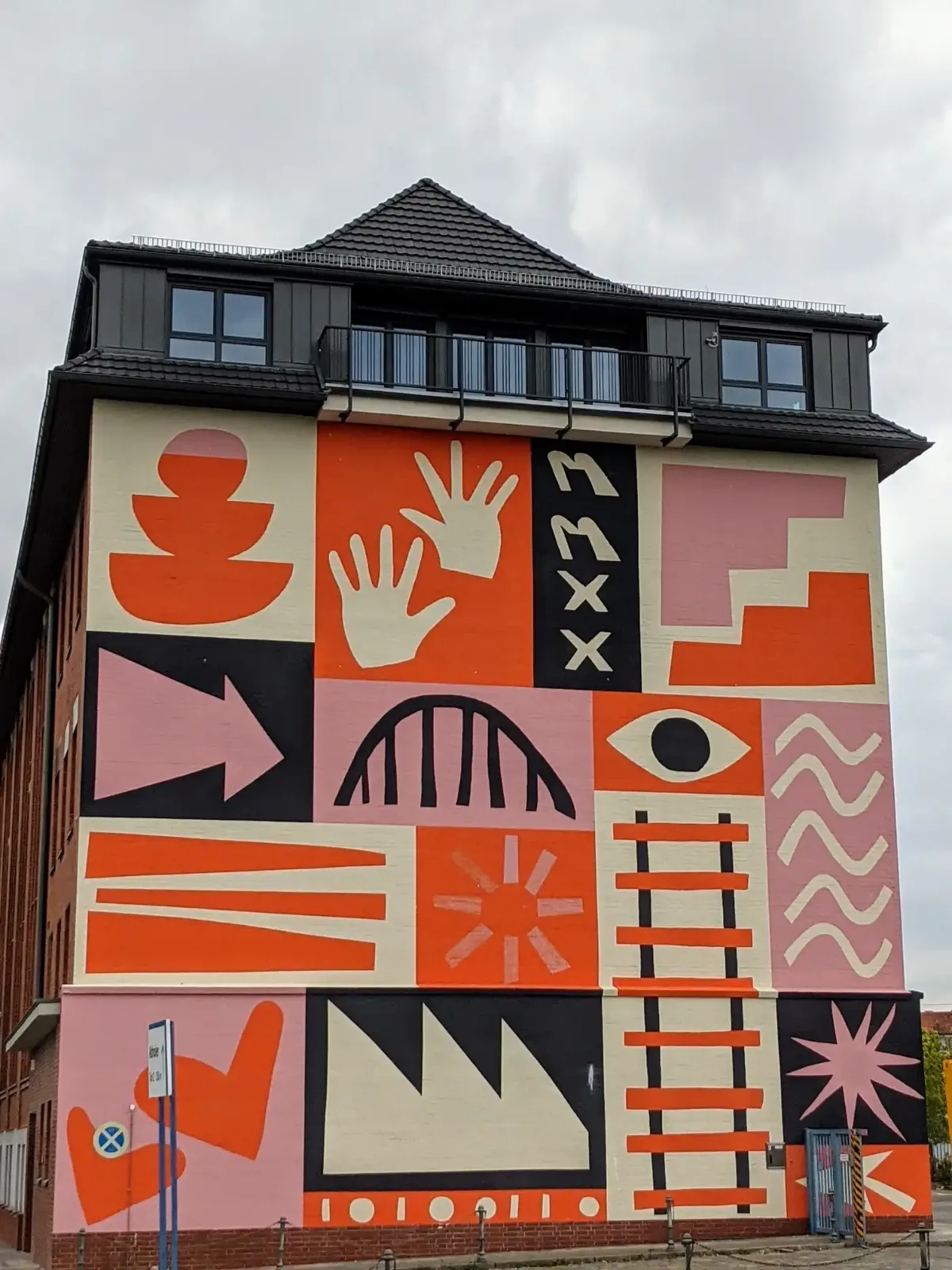 Grafisch bemalte Giebelwand eines Eckhauses am Rand des Sprengelkiezes in Berlin-Wedding in Orange, Rosa und Schwarz