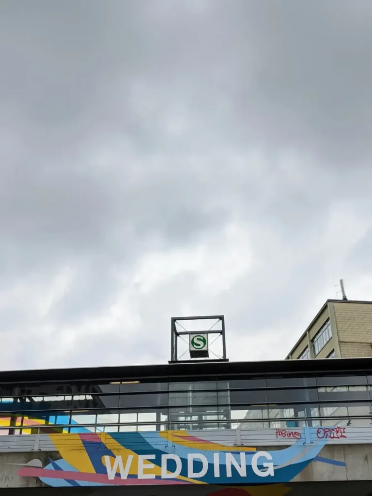 Bahnbrücke am S+U-Bahnhof Wedding in Berlin mit buntem Wandbild und Schriftzug Wedding