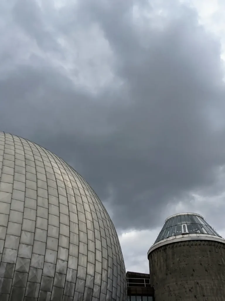 Silberne Kuppel des Zeiss-Großplanetariums an der Prenzlauer Allee unter dunklen Wolken