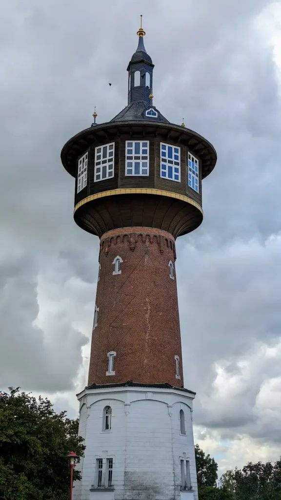 Backsteinturm des ehemaligen Wasserwerks in Schwedt mit umlaufendem Obergeschoss und dunkler Haube
