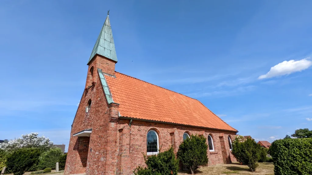 Kirche St. Nikolai in Ording, Backsteinkirche mit rotem Dach und grünem Turmdach