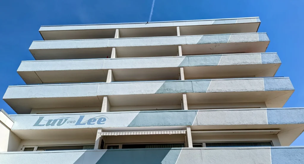 Mehrstöckiger Apartmentbau mit Balkonen und dem Schriftzug Luv und Lee in Bad St. Peter-Ording