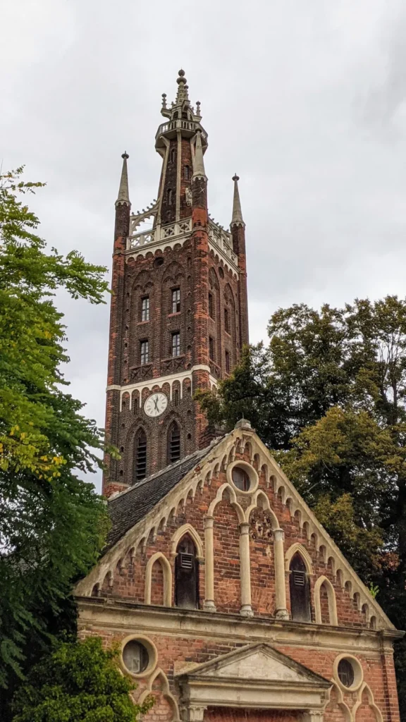 Turm der Kirche St. Petri in Wörlitz über einem neugotischen Backsteingiebel