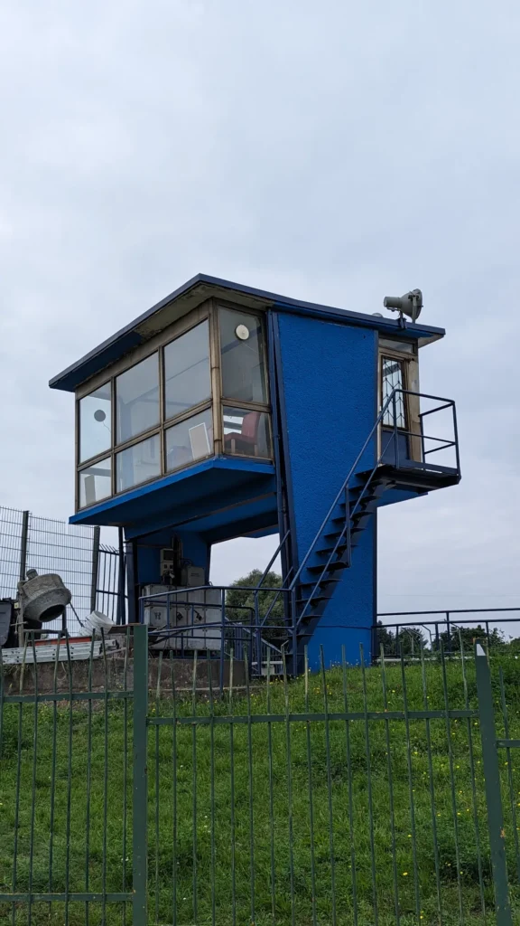Blauer Sprecherturm auf Stelzen im Stadion am Quenz, von der Rückseite gesehen