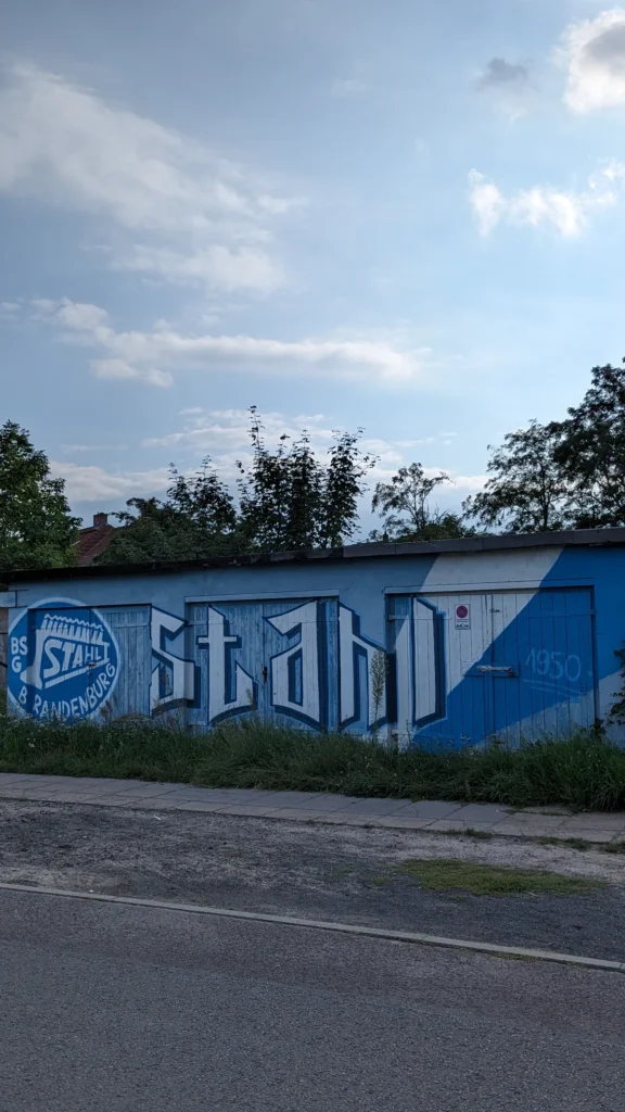 Blau-weißes Graffito mit dem Schriftzug Stahl und Vereinswappen an einer Garagenwand
