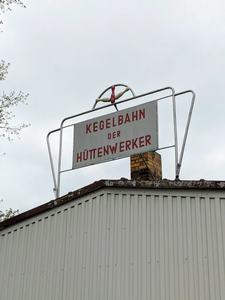 Altes Schild Kegelbahn der Hüttenwerker in roten Buchstaben auf dem Dach eines Flachbaus