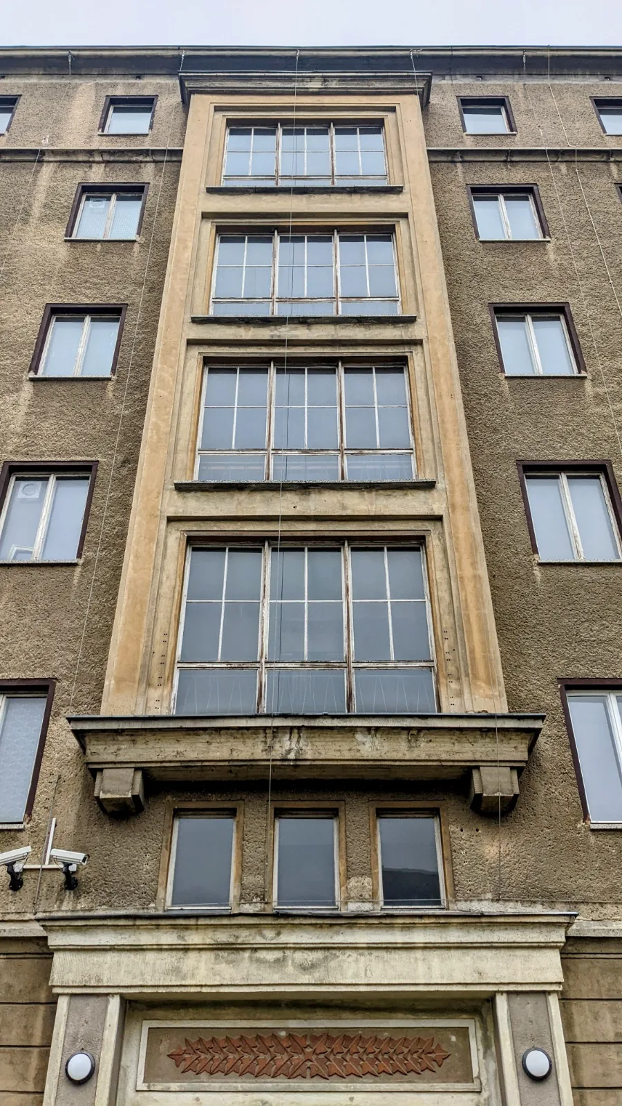 Mehrgeschossige Fassade mit hohen Fensterbändern und Portal an der ehemaligen Stasi-Zentrale in Berlin-Lichtenberg