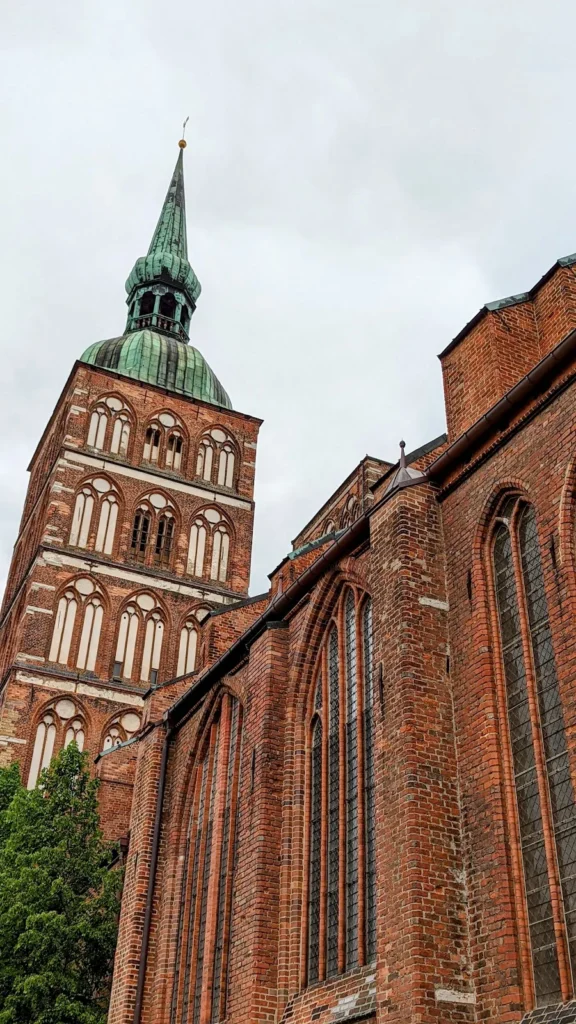Backsteinwand der Nikolaikirche in Stralsund mit dem Südturm und seiner barocken Kupferhaube