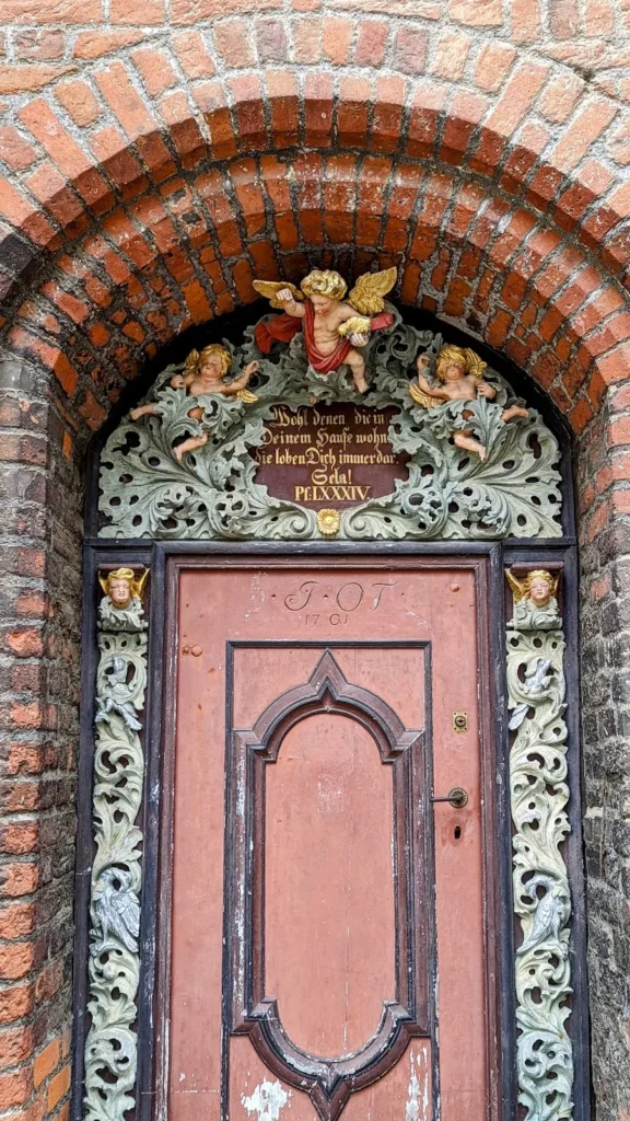 Westportal der Nikolaikirche in Stralsund mit Engelsfiguren und Inschrift aus Psalm 84 über der Tür