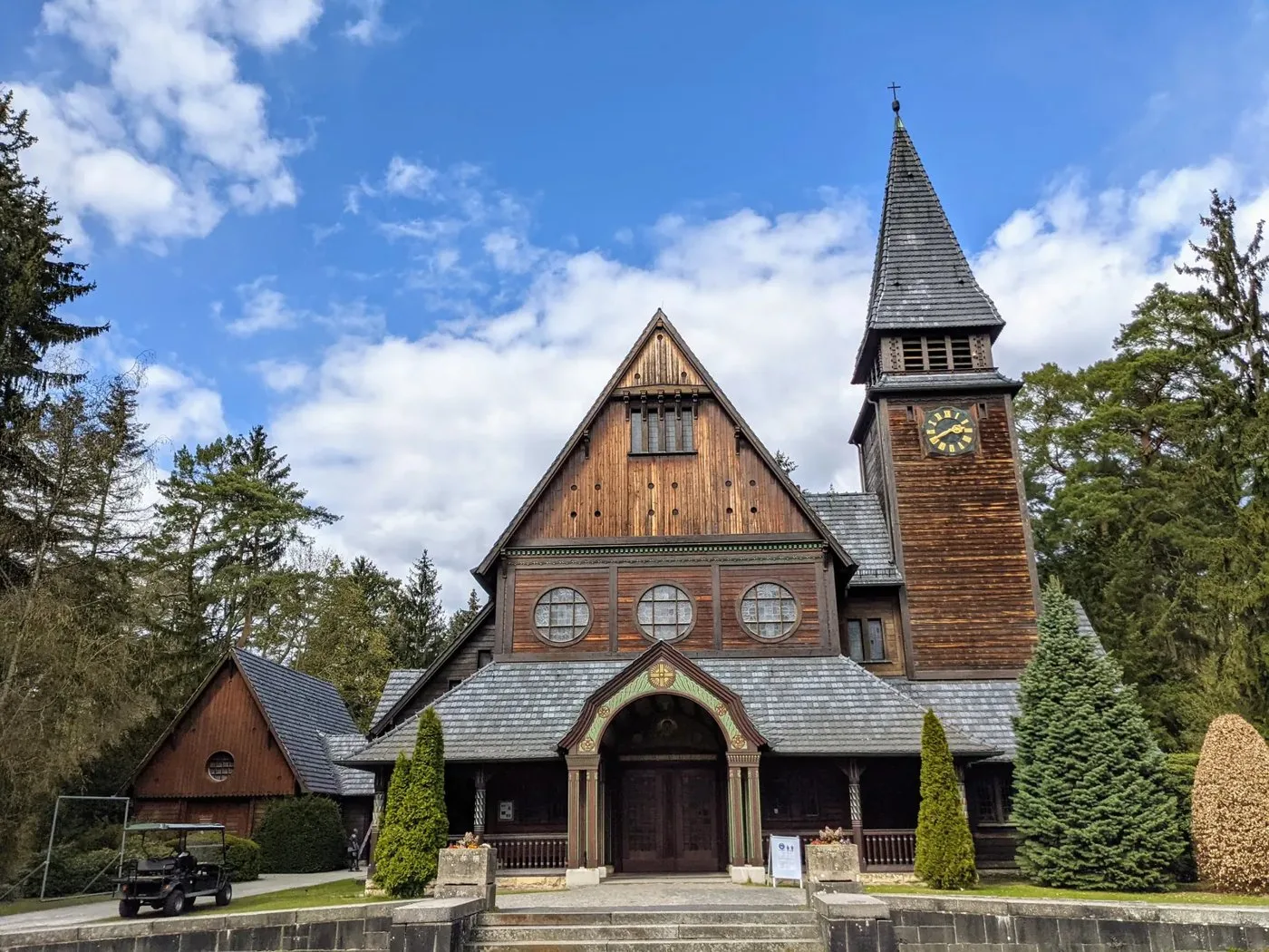 Die Holzkapelle des Südwestkirchhofs mit steilem Dach, Uhrturm und Vorbau