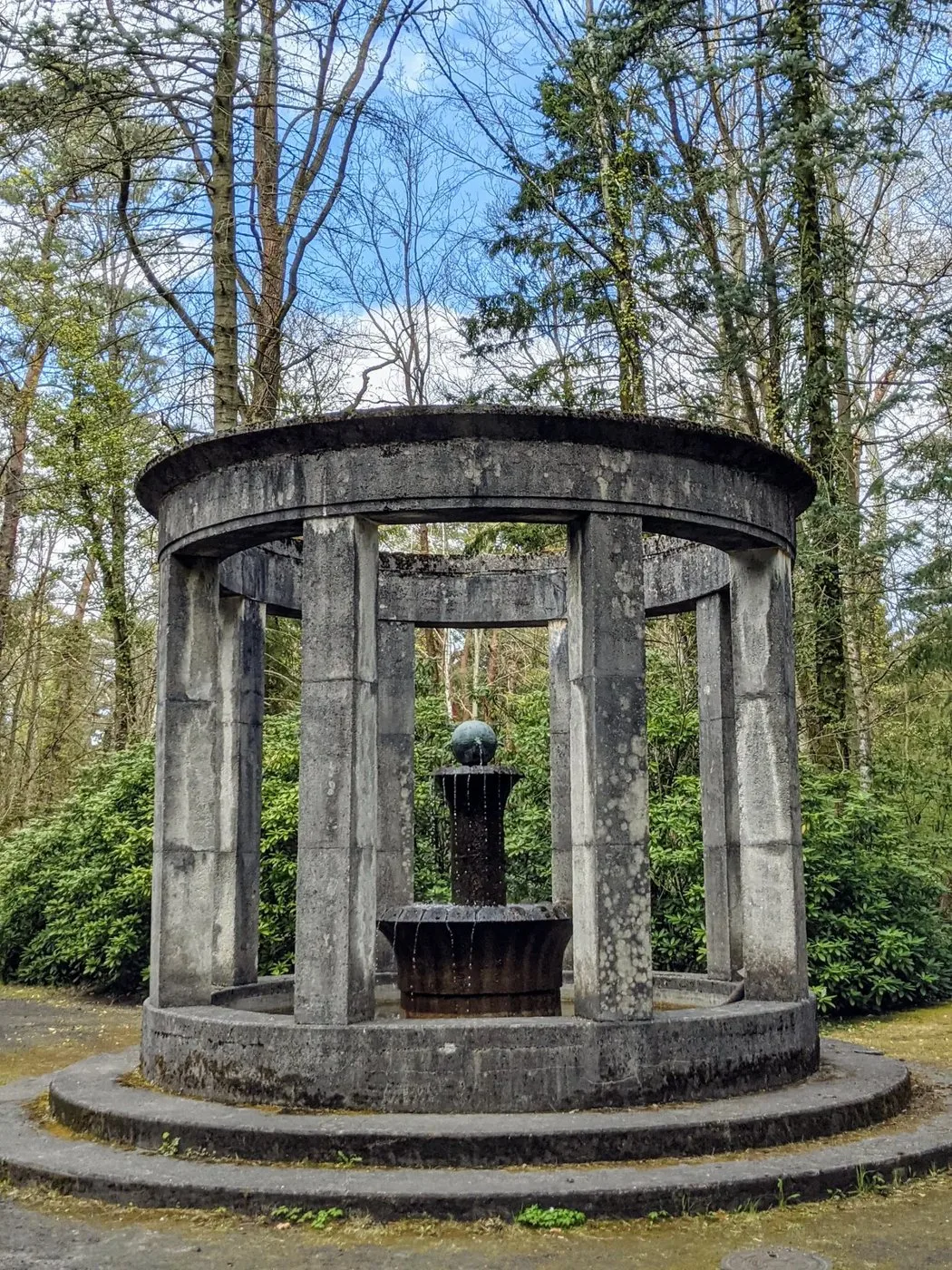 Runder Säulenbau mit Brunnen im Wald