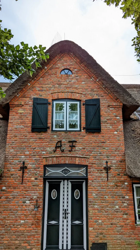 Giebel eines Klinkerhauses mit Reetdach und Haustür in Keitum auf Sylt