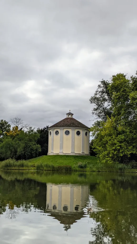 Synagoge Wörlitz, weißer Rundbau auf einem Hügel am See, der sich im Wasser spiegelt