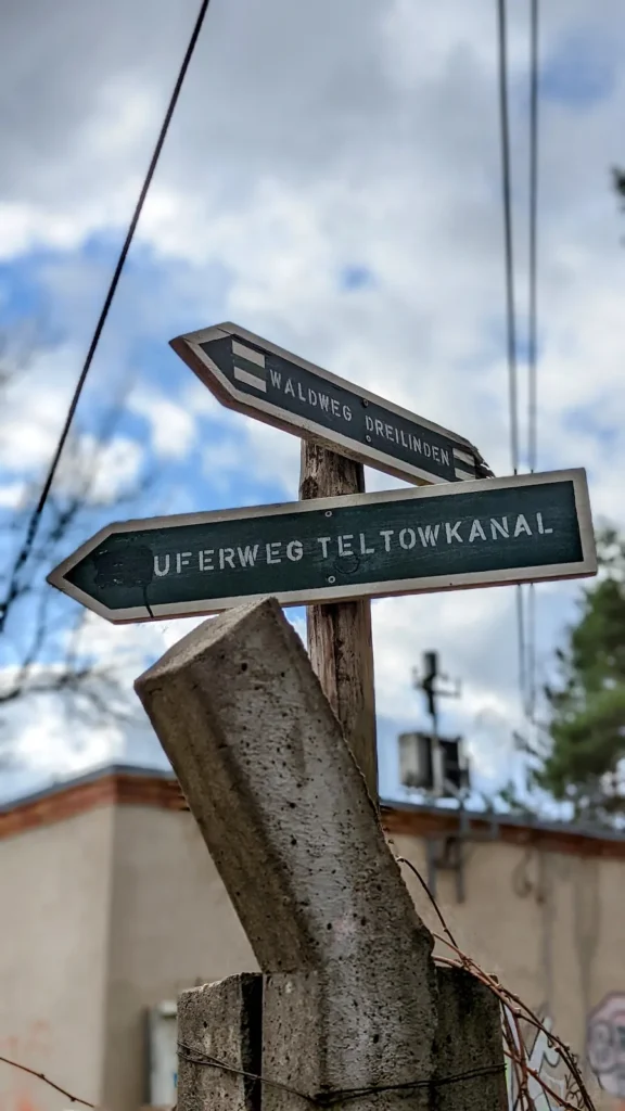 Wegweiser Uferweg Teltowkanal an einem Mast am Teltowkanal