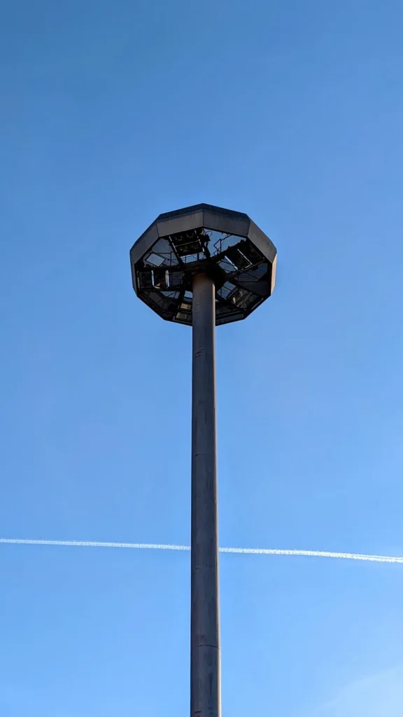Hohe Straßenlaterne mit achteckigem Schirm vor blauem Himmel am Flughafen Tempelhof