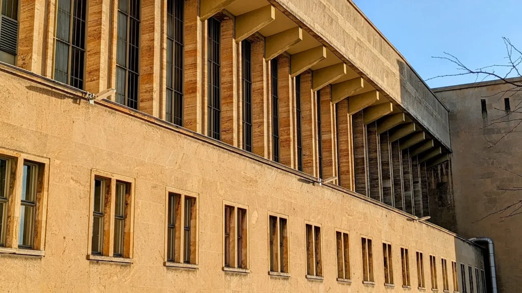 Seitenwand des ehemaligen Flughafengebäudes Tempelhof mit Steinfassade und Fensterreihen