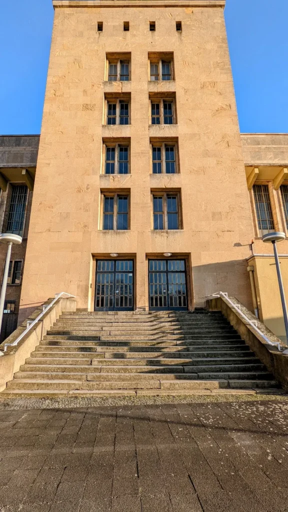 Turm am ehemaligen Flughafengebäude Tempelhof mit Flugfeld im Hintergrund