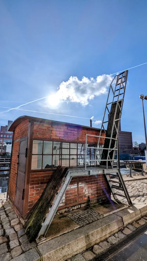 Backsteinhäuschen mit Fenstern und Metalltreppe am Kai des Hafens Tempelhof