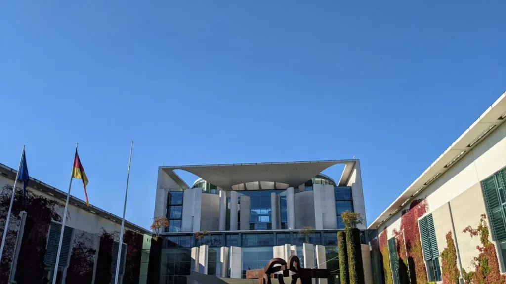 Blick auf den Mittelbau des Bundeskanzleramts mit Flaggen und begrünten Seitenflügeln