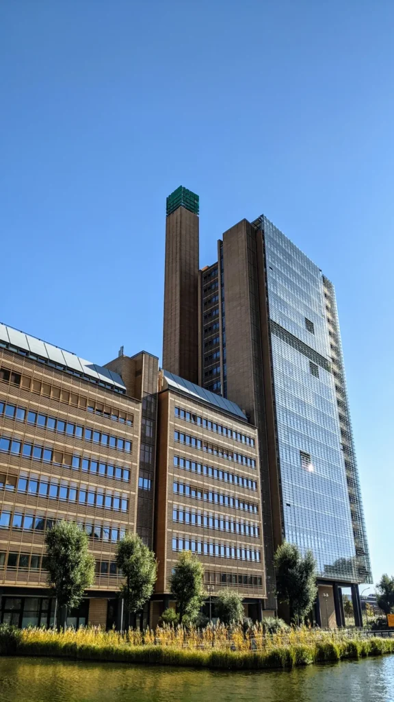 Früheres Debis-Haus am Potsdamer Platz mit Turm und grünem Würfel, davor Wasser und Schilf