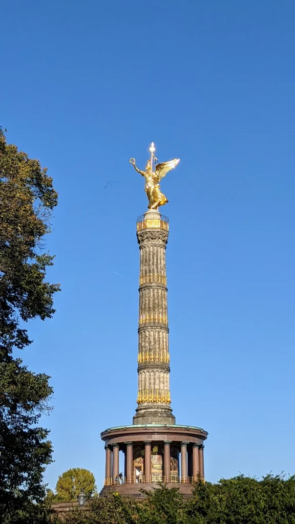 Siegessäule mit goldener Victoria am Großen Stern im Tiergarten vor blauem Himmel