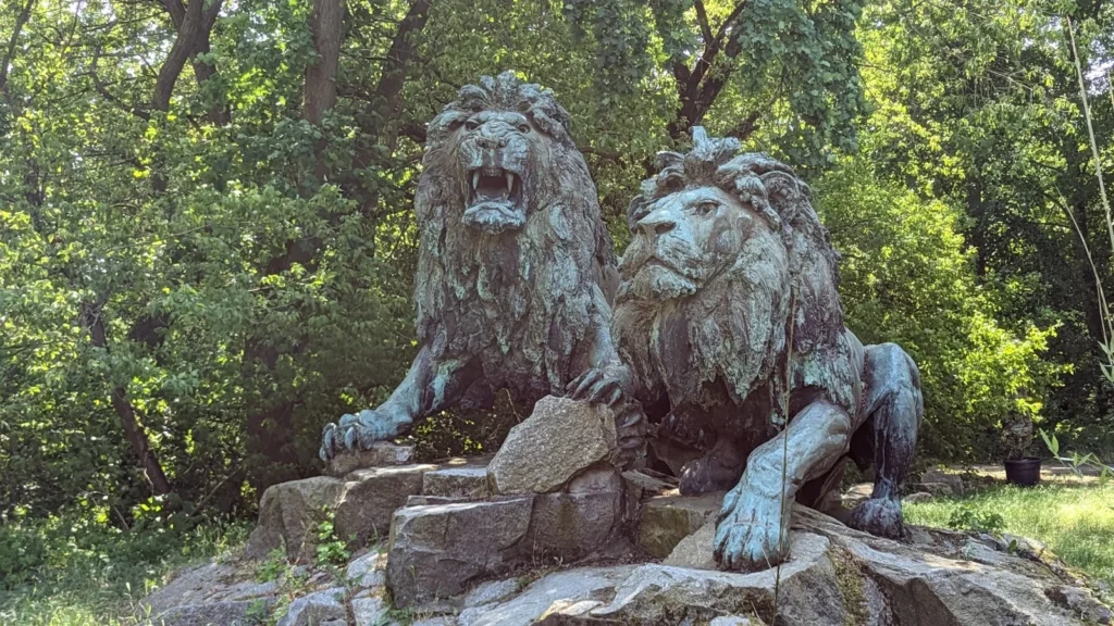 Zwei Bronzelöwen auf einem Felssockel im Tierpark Berlin