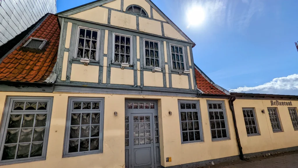 Gelbes Fachwerkhaus mit grauen Sprossenfenstern in der Altstadt von Travemünde