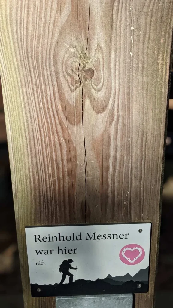 Holzbrett mit Schild und Wanderersymbol