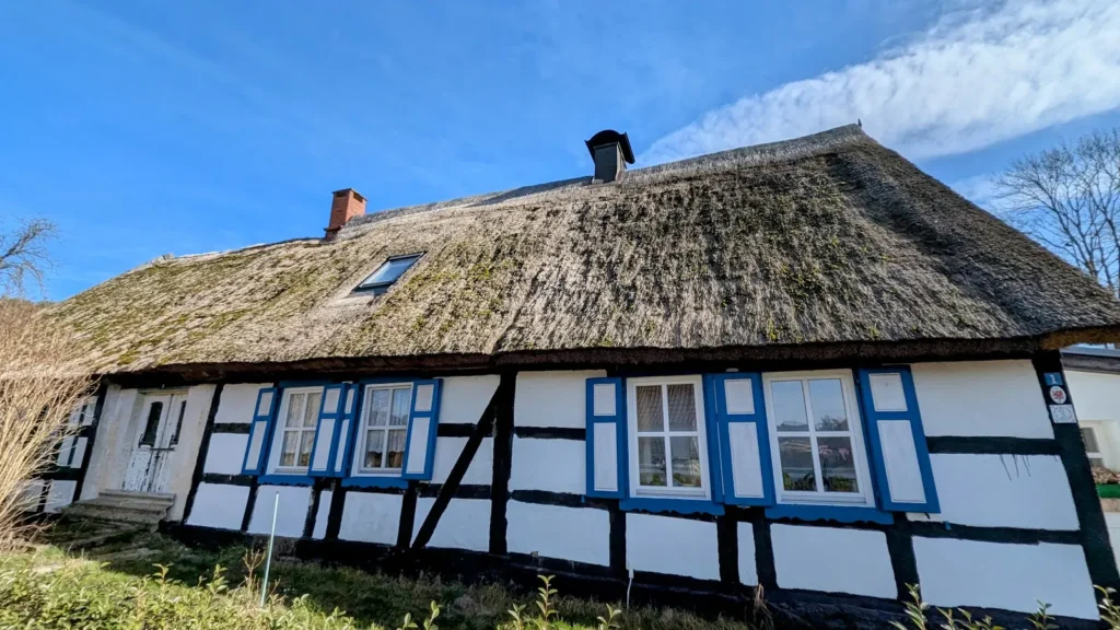 Fachwerkhaus mit Rohrdach und blauen Fensterläden in Stoben