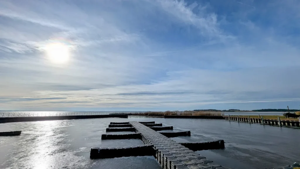 Schwimmstege im zugefrorenen Achterwasserhafen von Ückeritz im Gegenlicht