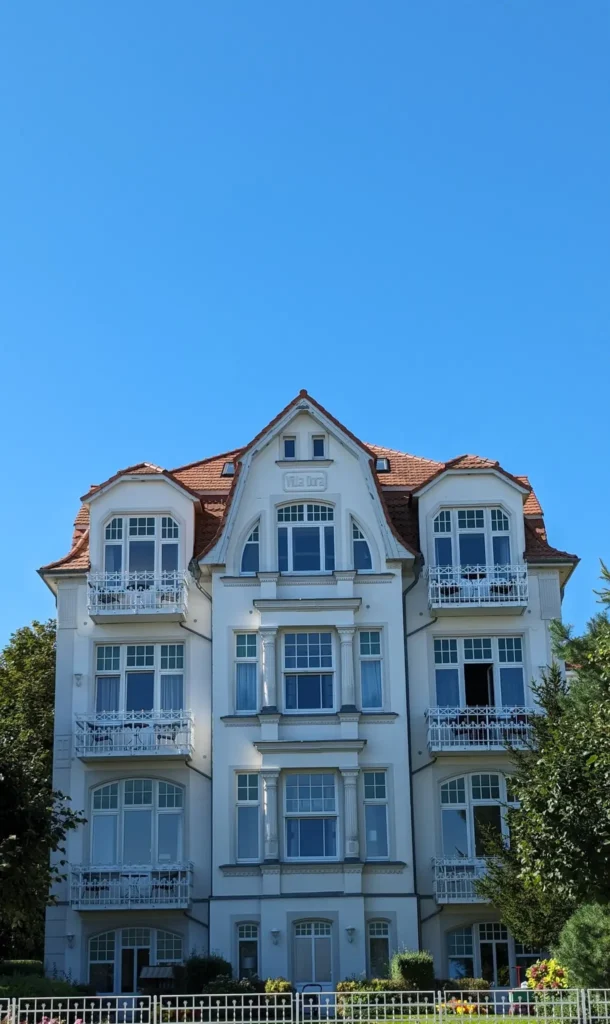 Villa Dora an der Strandpromenade von Bansin mit weißen Balkonen und rotem Ziegeldach
