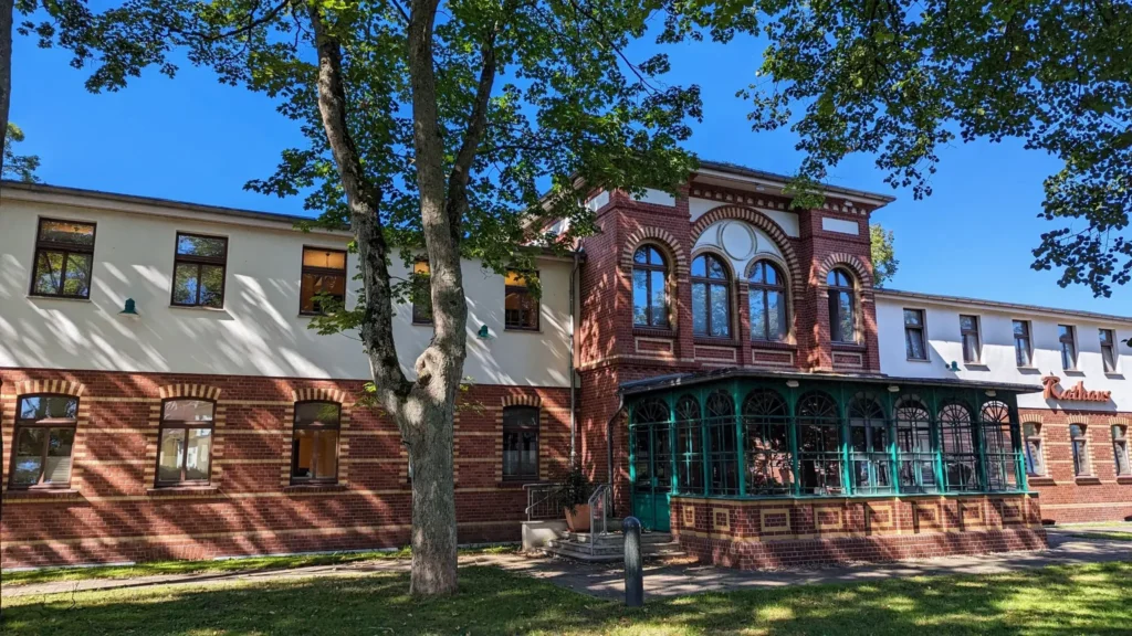 Rathaus in Ahlbeck, ein Backsteinbau mit grün gestrichener verglaster Veranda