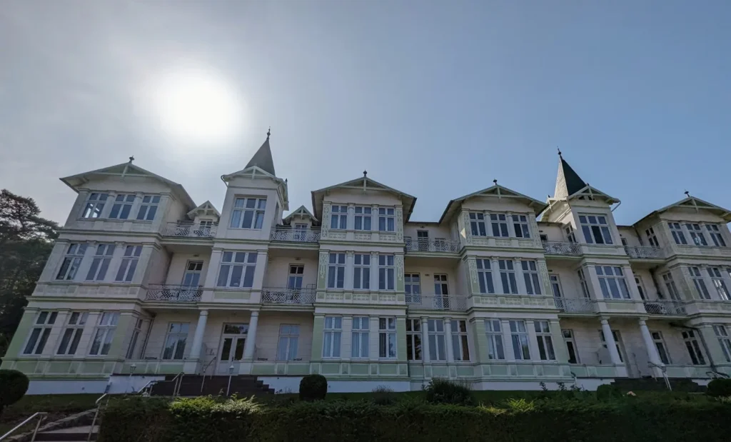 Langes weißes Gebäude der Bäderarchitektur mit Balkonen und Türmchen an der Strandpromenade von Zinnowitz