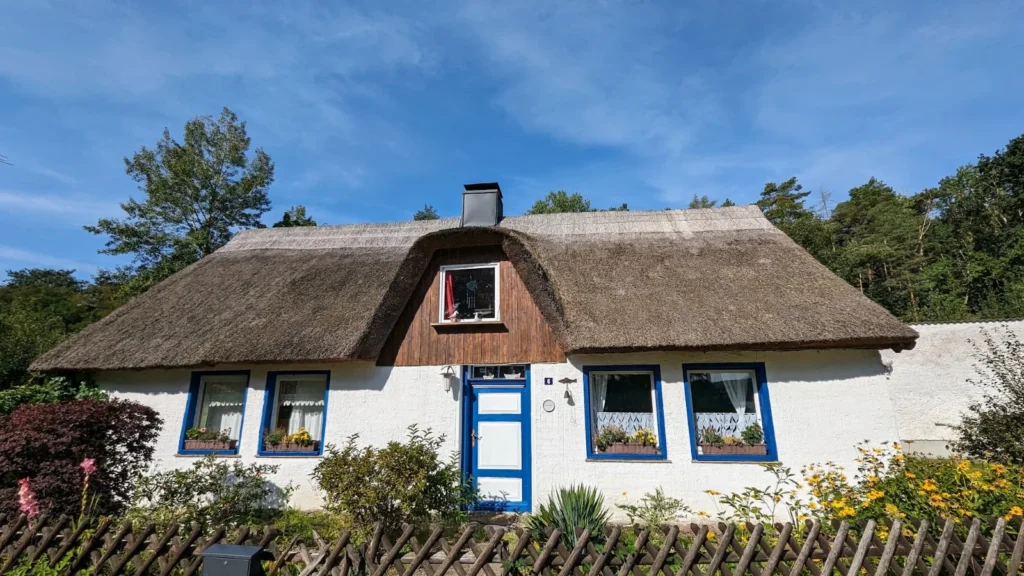 Weißes Haus mit Rohrdach und blauen Fenstern Am Fuchsberg