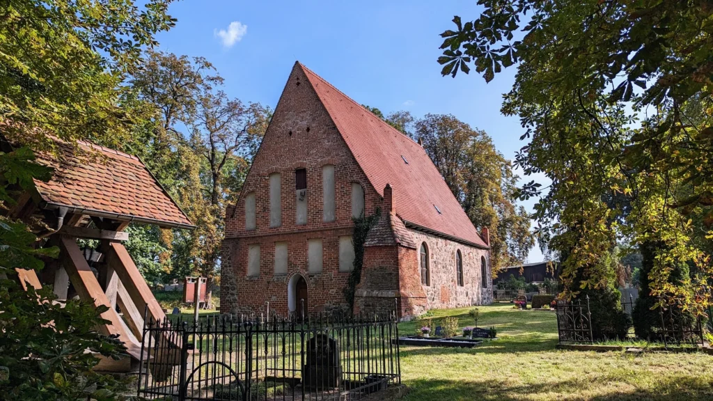Backsteingiebel der Dorfkirche Garz auf Usedom, links daneben der hölzerne Glockenstuhl