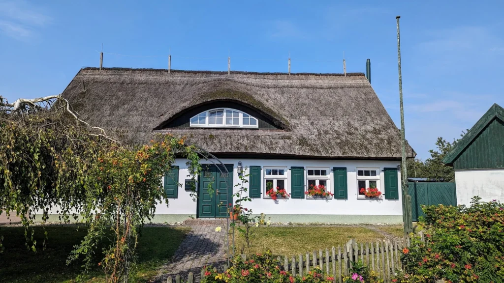 Rohrgedecktes Haus mit grünen Fensterläden und Fledermausgaube in Garz auf Usedom