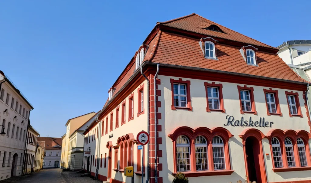 Ratskeller am Markt in Vetschau, rot-weißes Haus mit Rundbogenfenstern