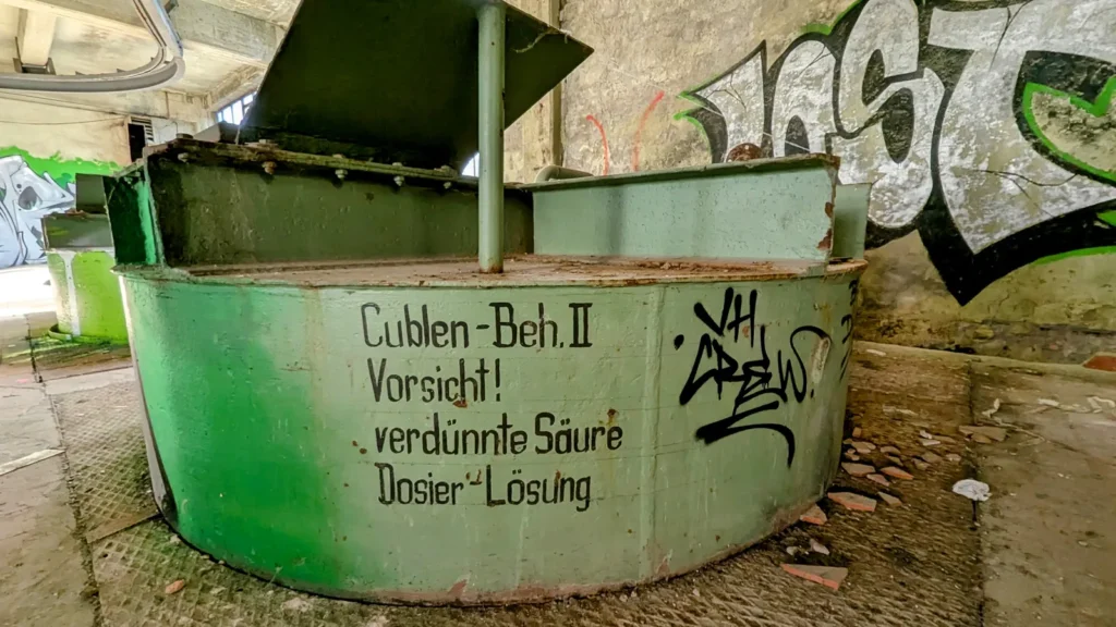 Grüner Behälter mit Warnaufschrift zu verdünnter Säure