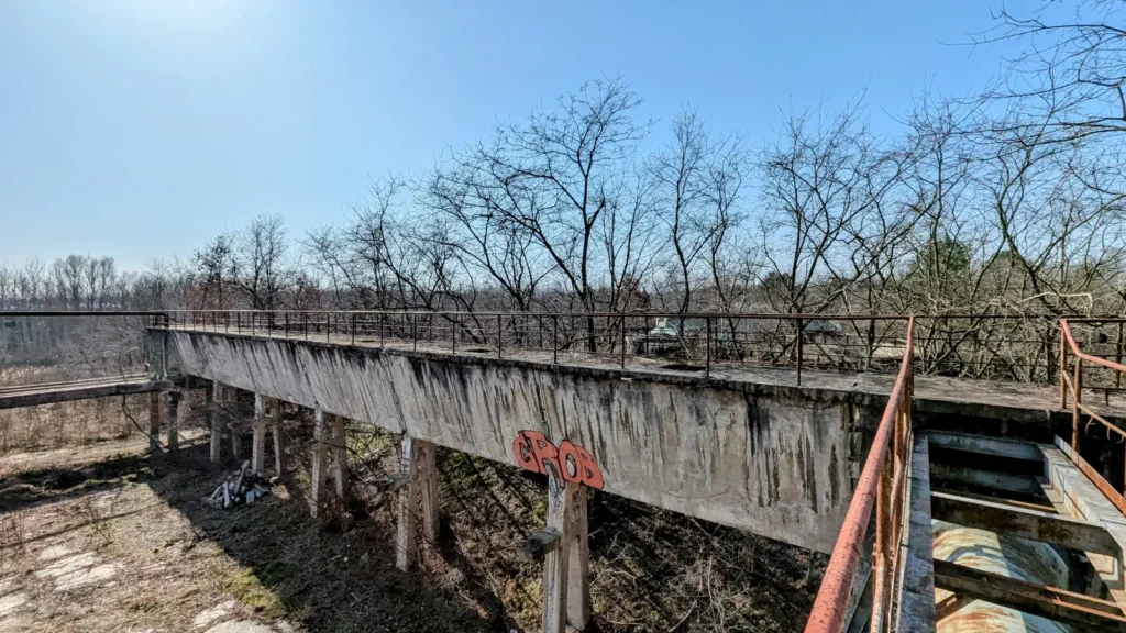 Betonierte Förderbrücke mit Geländer im Werksgelände