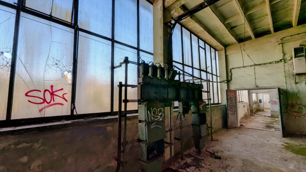 Leere Halle mit Fensterband und grünem Verteilerkasten