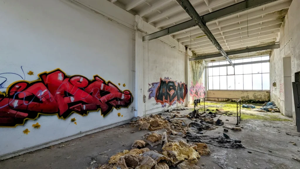 Rotes Graffiti an der Wand einer leeren Halle