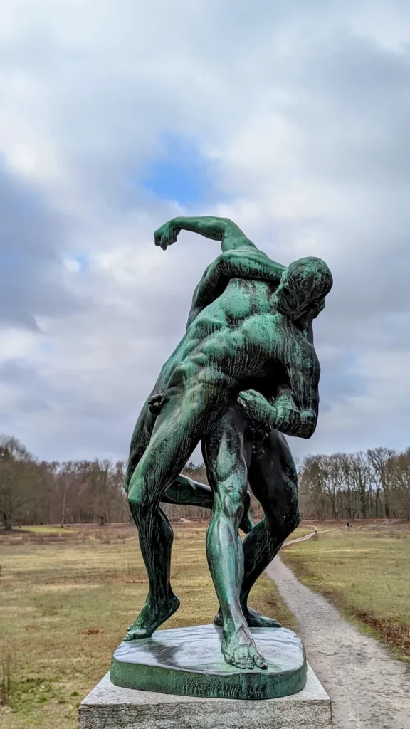 Bronzene Ringergruppe von Wilhelm Haverkamp auf einem Steinsockel auf einer Wiese im Volkspark Rehberge