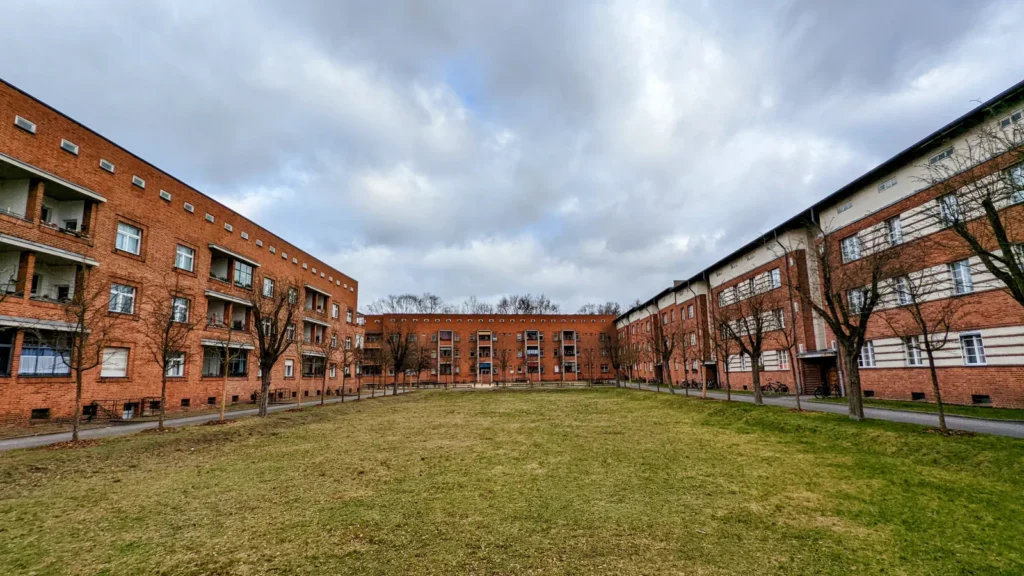 Rasenhof zwischen dreigeschossigen Backsteinhäusern mit Loggien in der Schillerpark-Siedlung von Bruno Taut