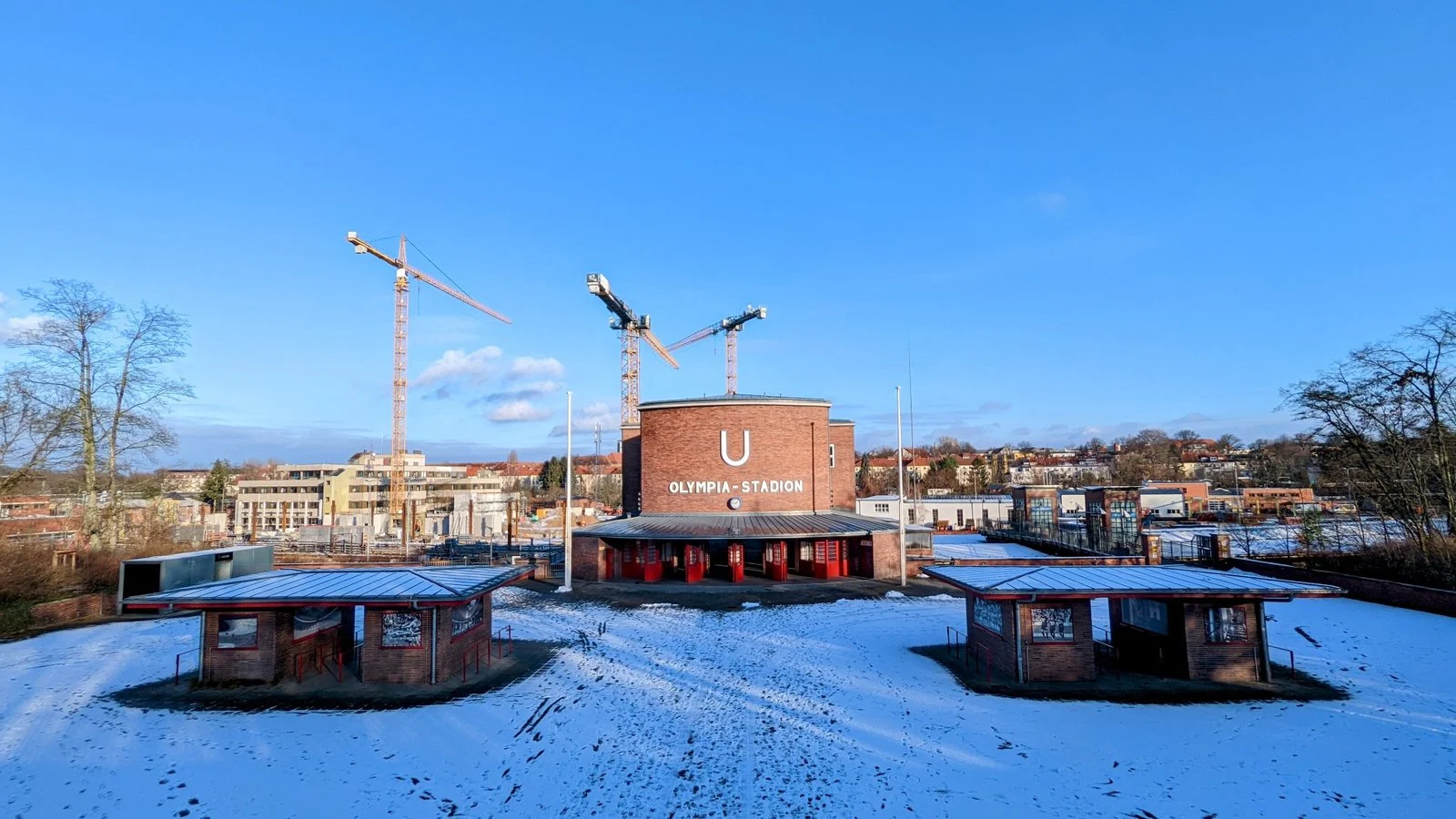 Klinker-Empfangsgebäude und Fahrkartenhäuschen des U-Bahnhofs Olympia-Stadion am Rossitter Platz im Schnee